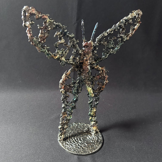 Sculpture de Philippe Buil représentant un papillon en dentelle de métal, symbole de légèreté et de transformation.
