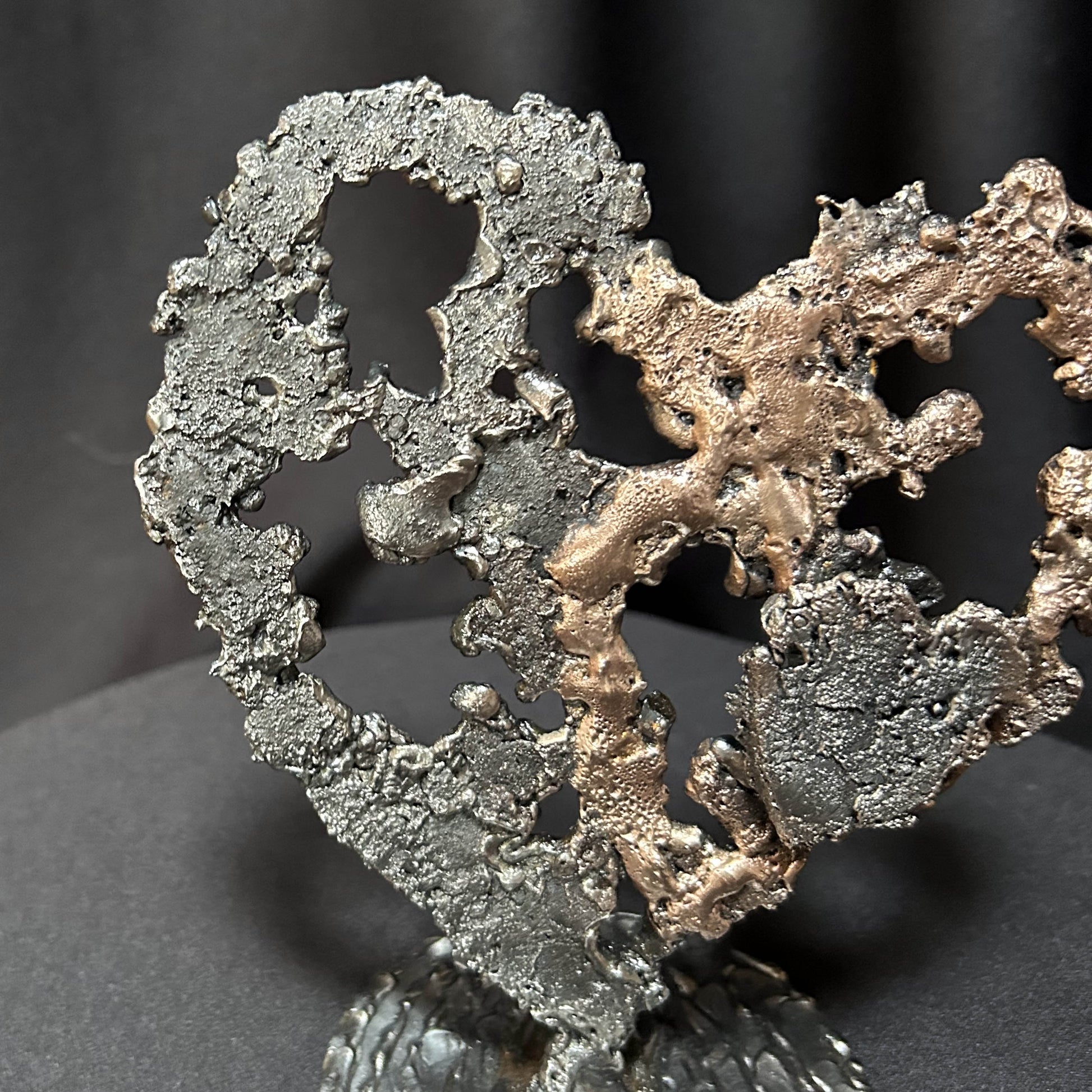 Sculpture de cœur en dentelle de métal noir et bronze par Philippe Buil, détail matière.