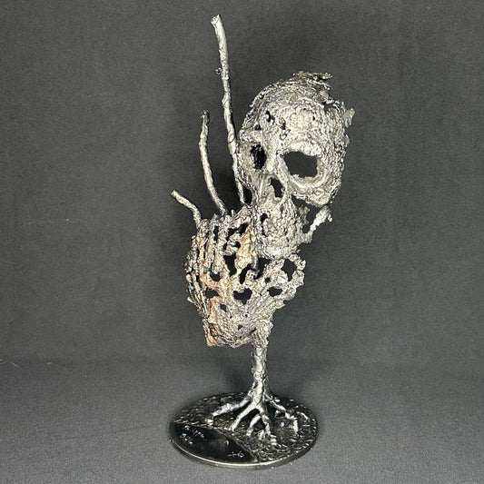 Sculpture en dentelle de métal représentant une tête de mort associée à une coquille Saint-Jacques, réalisée en acier et bronze par Philippe Buil.