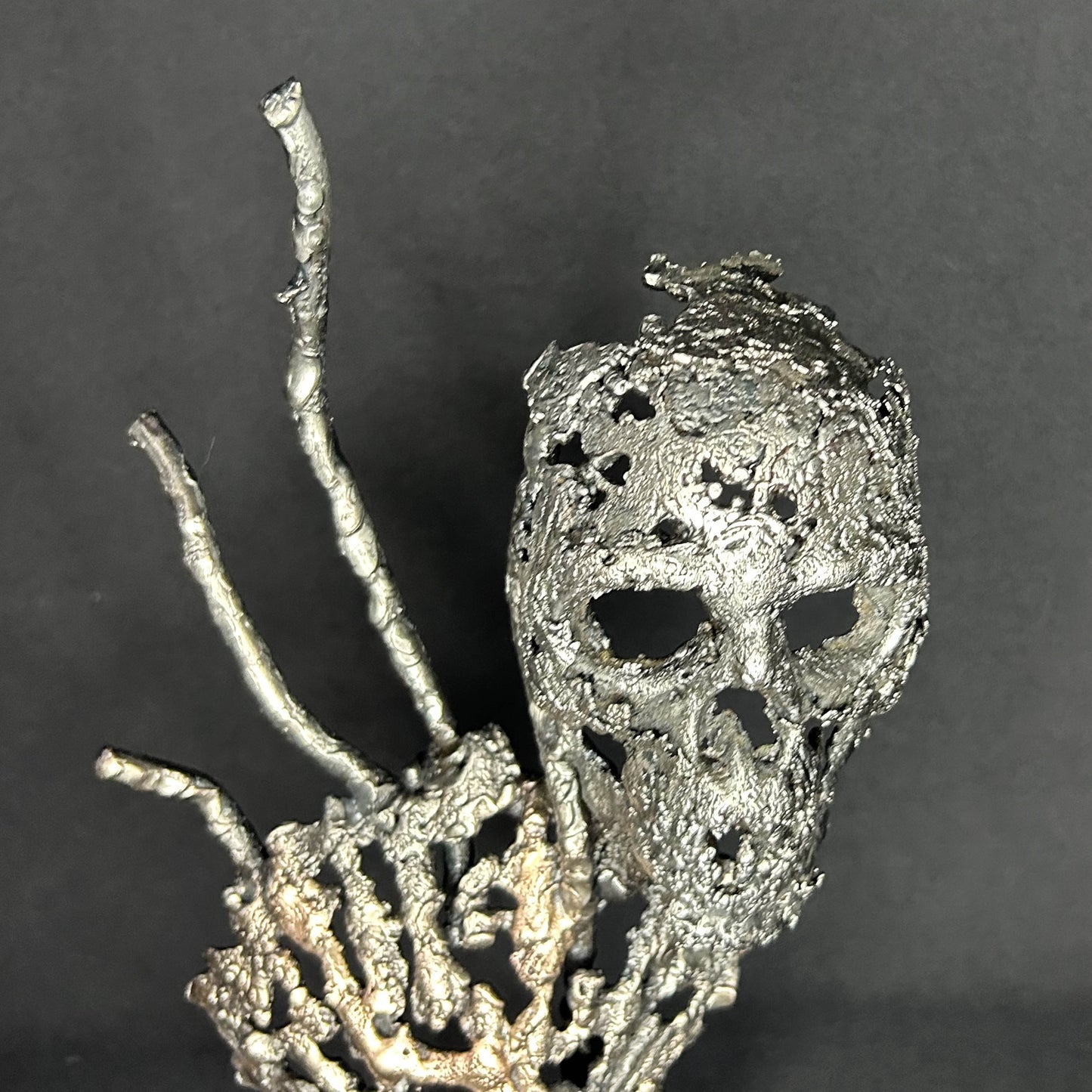 Sculpture en dentelle de métal représentant une tête de mort associée à une coquille Saint-Jacques, réalisée en acier et bronze par Philippe Buil.