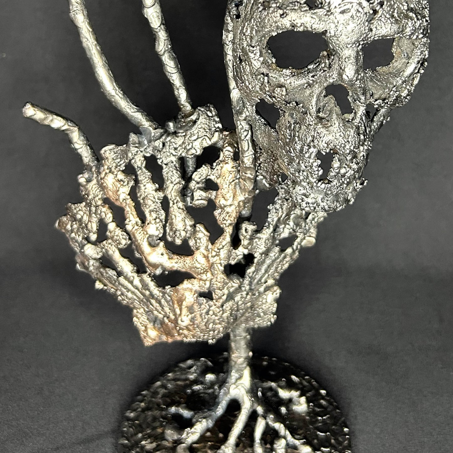 Sculpture en dentelle de métal représentant une tête de mort associée à une coquille Saint-Jacques, réalisée en acier et bronze par Philippe Buil.