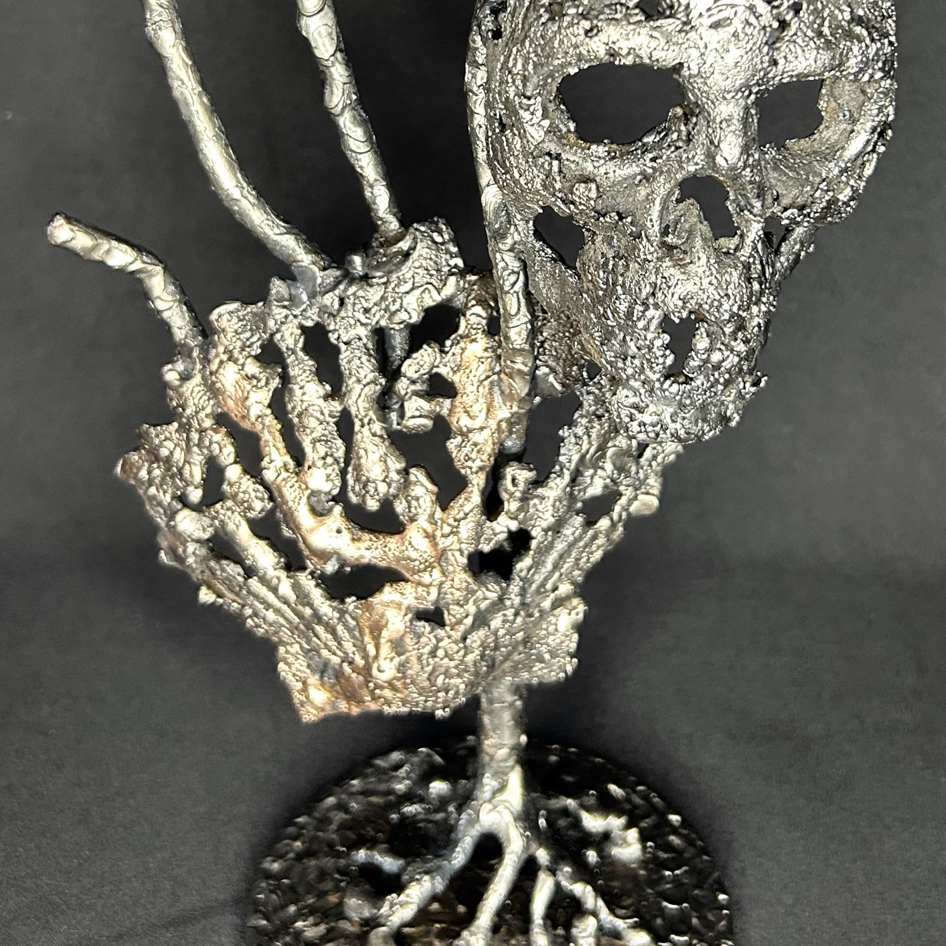 Sculpture en dentelle de métal représentant une tête de mort associée à une coquille Saint-Jacques, réalisée en acier et bronze par Philippe Buil.