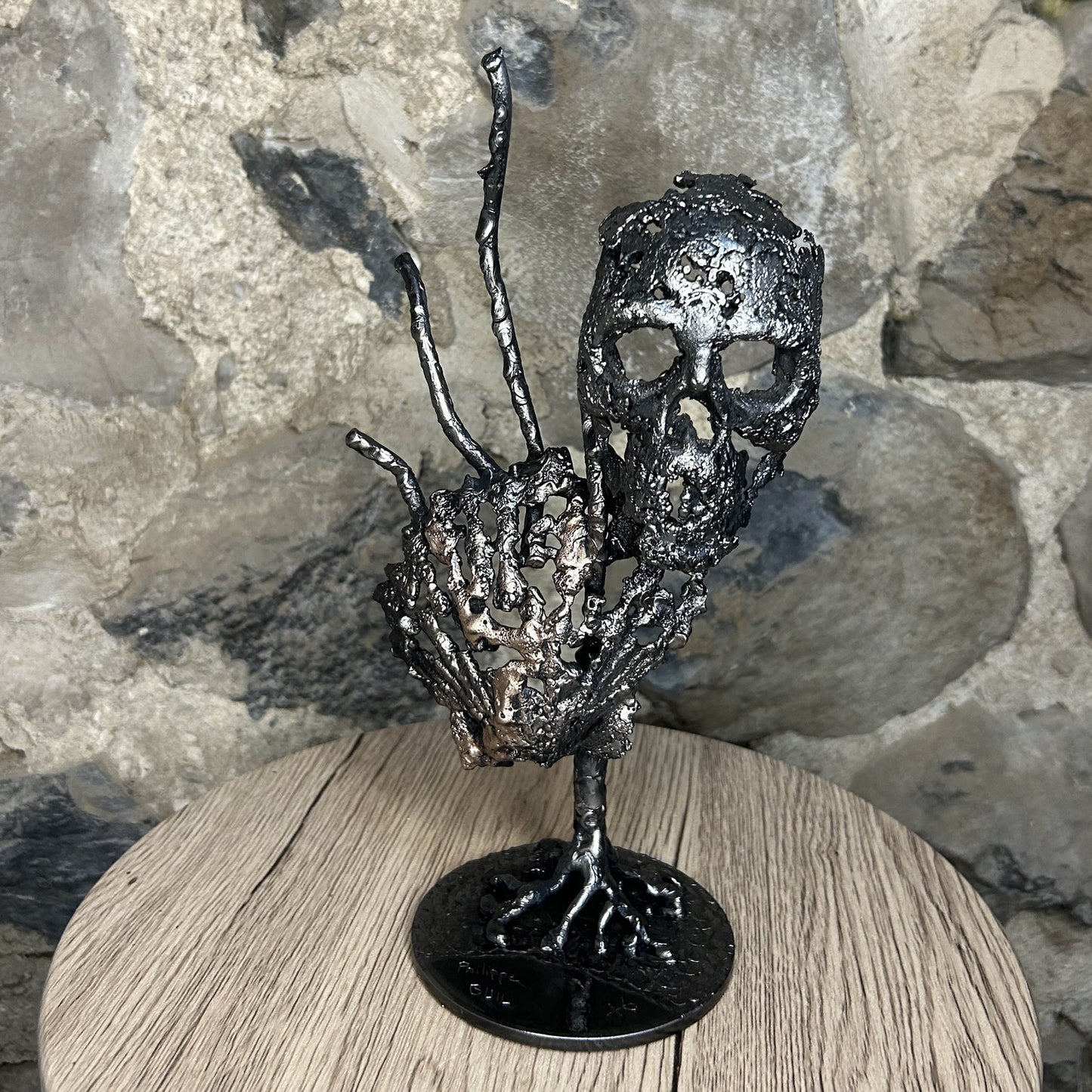 Sculpture en dentelle de métal représentant une tête de mort associée à une coquille Saint-Jacques, réalisée en acier et bronze par Philippe Buil.