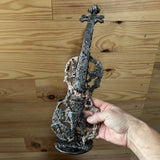 L'artiste nous présente dans sa main, sa sculpture intitulée le sillage du violon et réalisée en 2026 en dentelle de métal