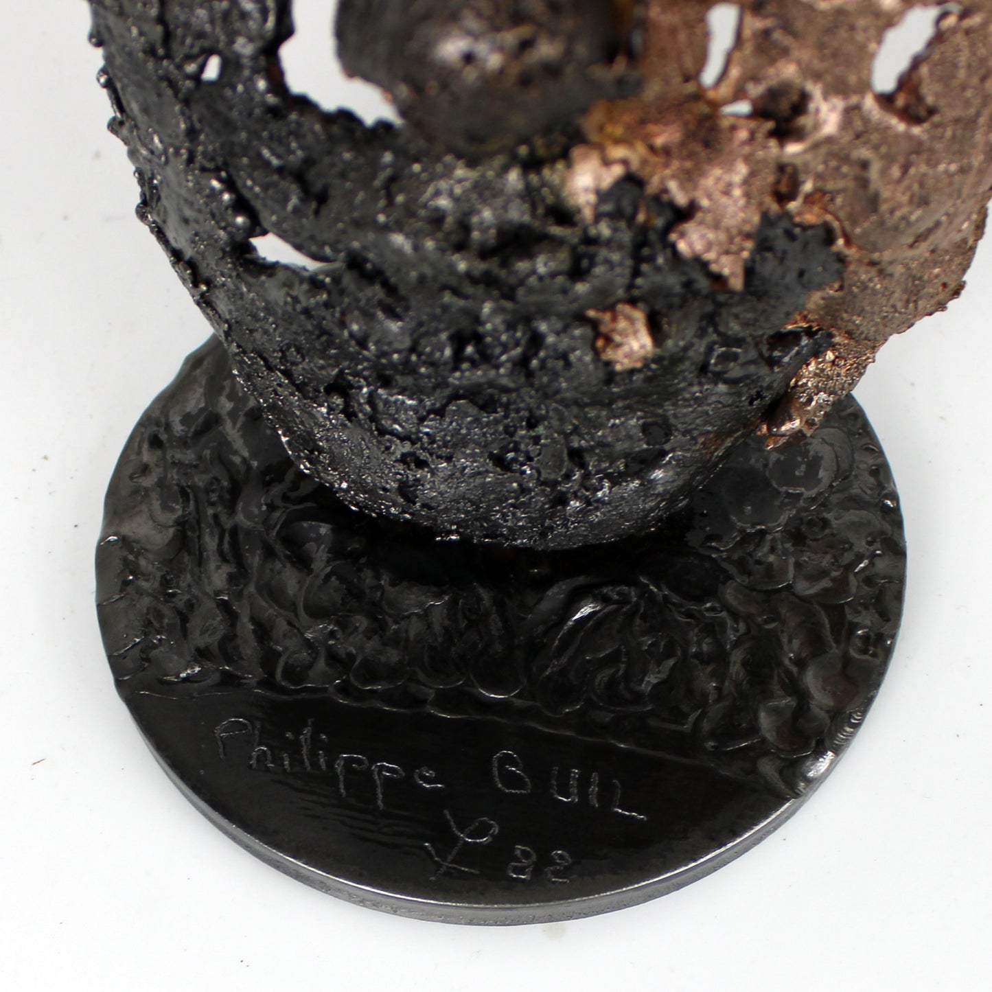 Cette sculpture représente un visage humain, créé avec une technique de dentelle de métal unique.