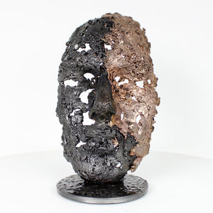 Cette sculpture représente un visage humain, créé avec une technique de dentelle de métal unique.