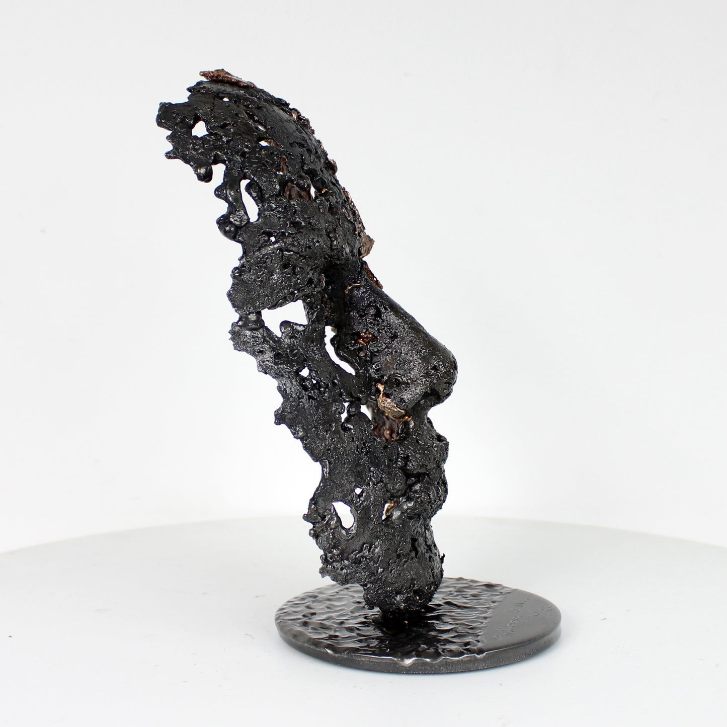 Cette sculpture représente un visage humain, créé avec une technique de dentelle de métal unique.