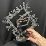 Sculpture contemporaine Les Carrés du Secret de Philippe Buil, acier et bronze, dans la main de l'artiste