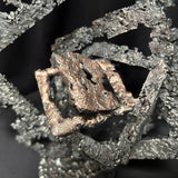 Détail bronze au centre de la sculpture Les Carrés du Secret