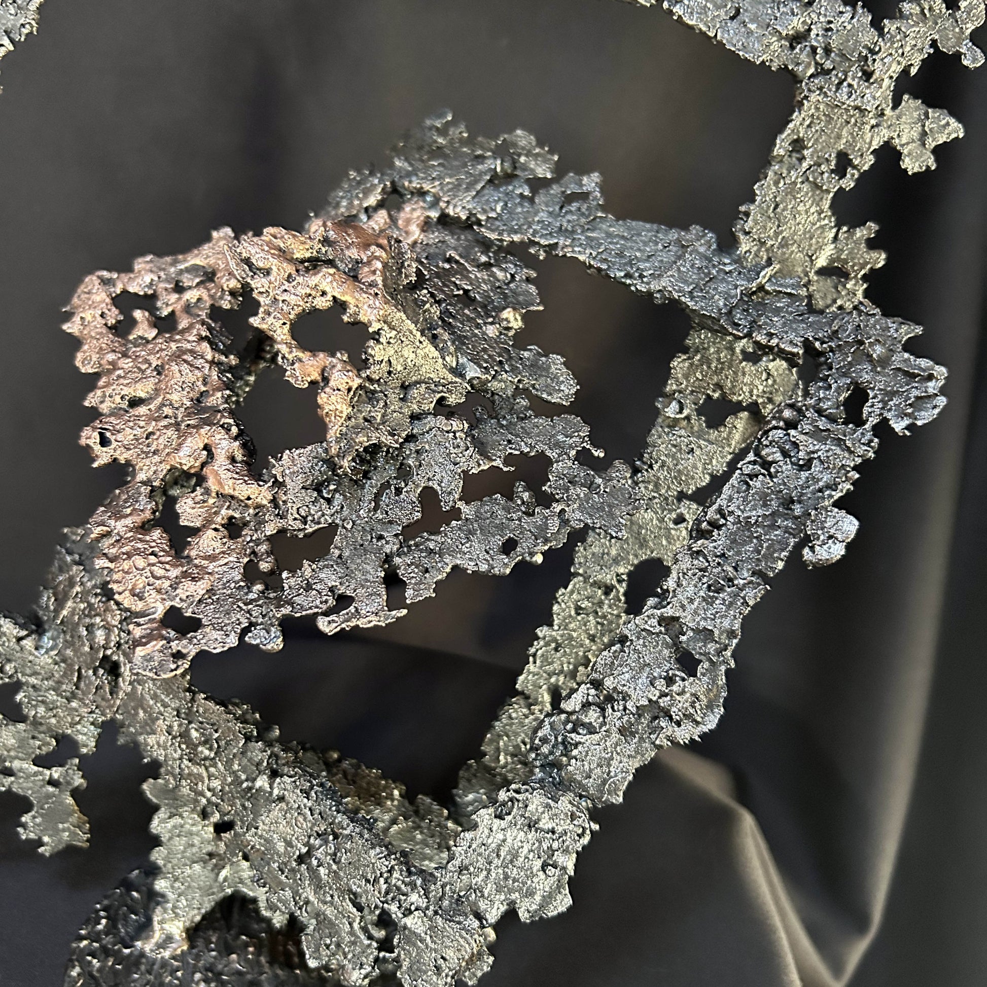« Détail du noyau central en bronze de la sculpture Le Diamant du Seuil, texture organique et reliefs métalliques. »
