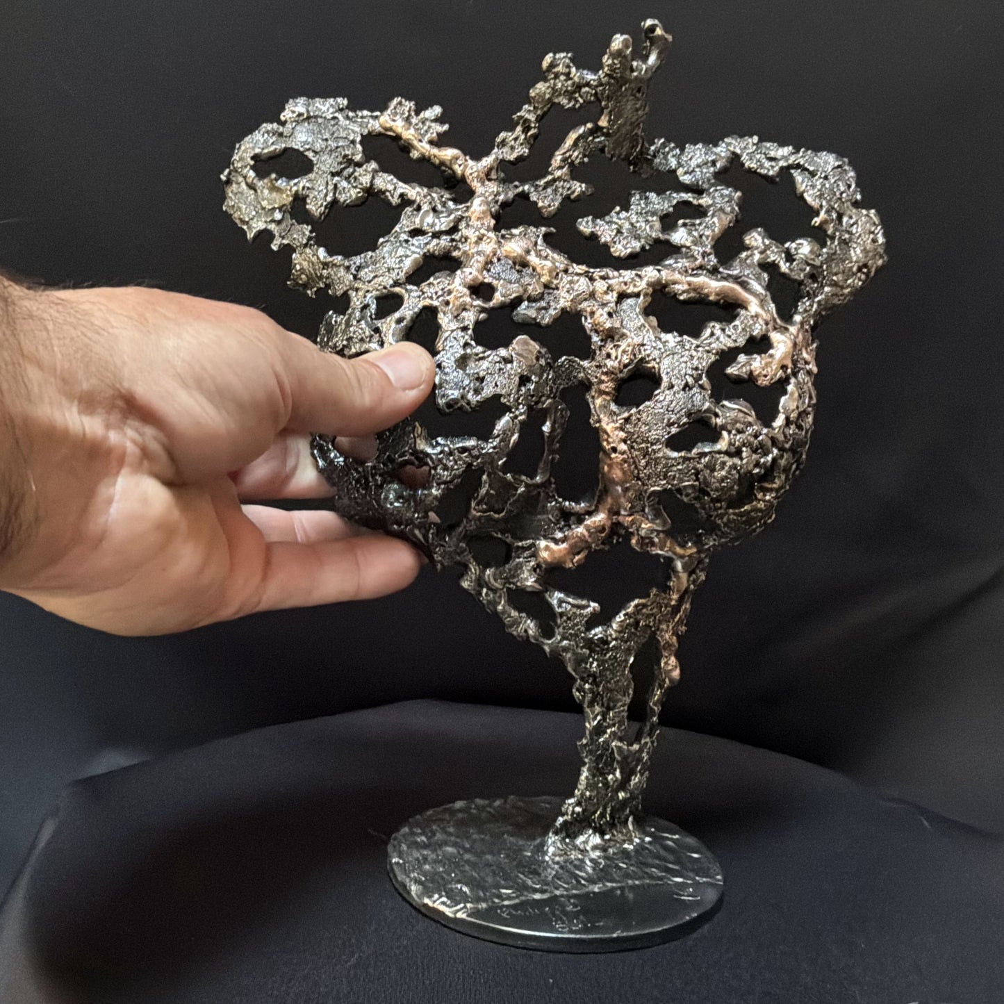 Détail de la texture organique en acier et bronze de la sculpture Pavarti Éclosion