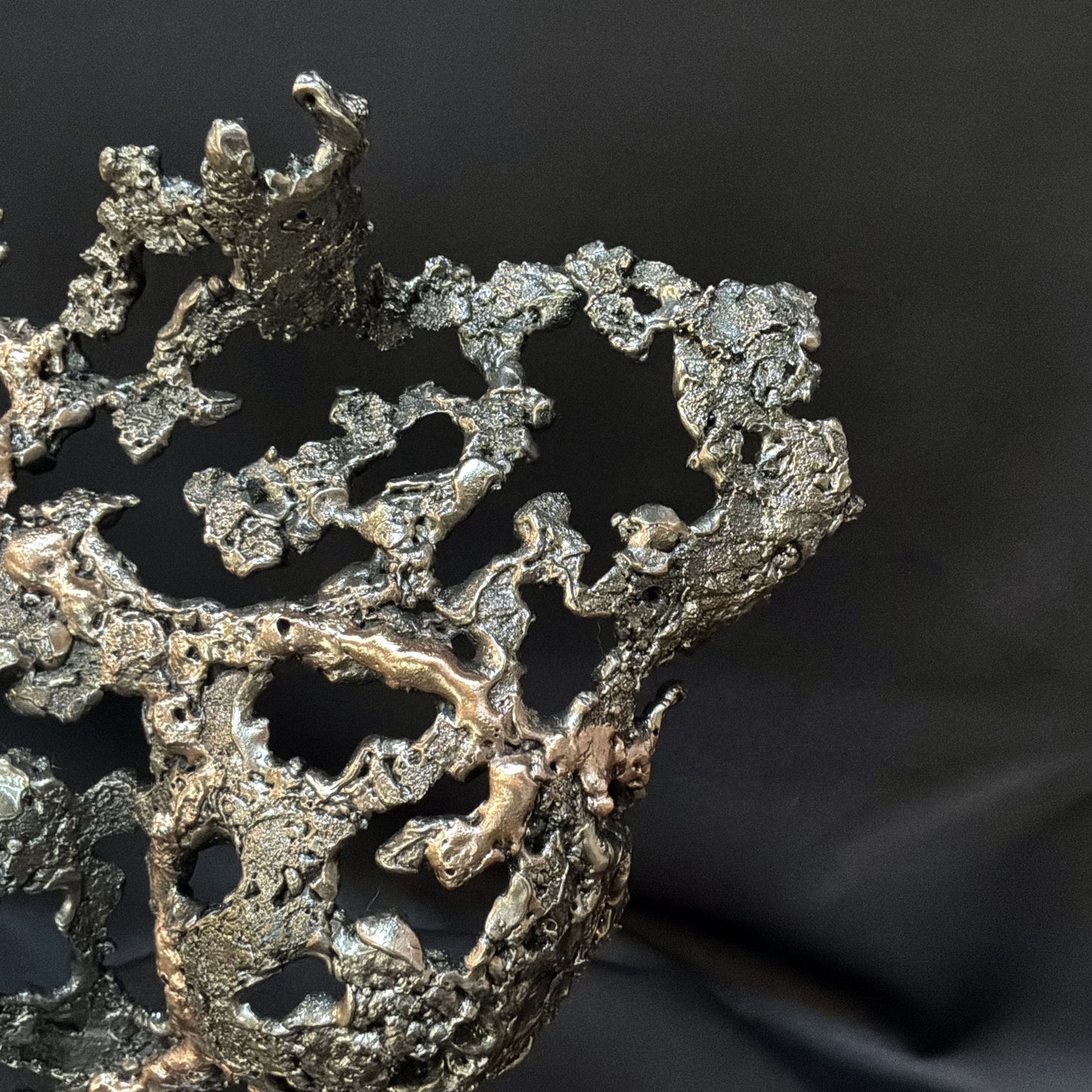 Détail de la texture organique en acier et bronze de la sculpture Pavarti Éclosion