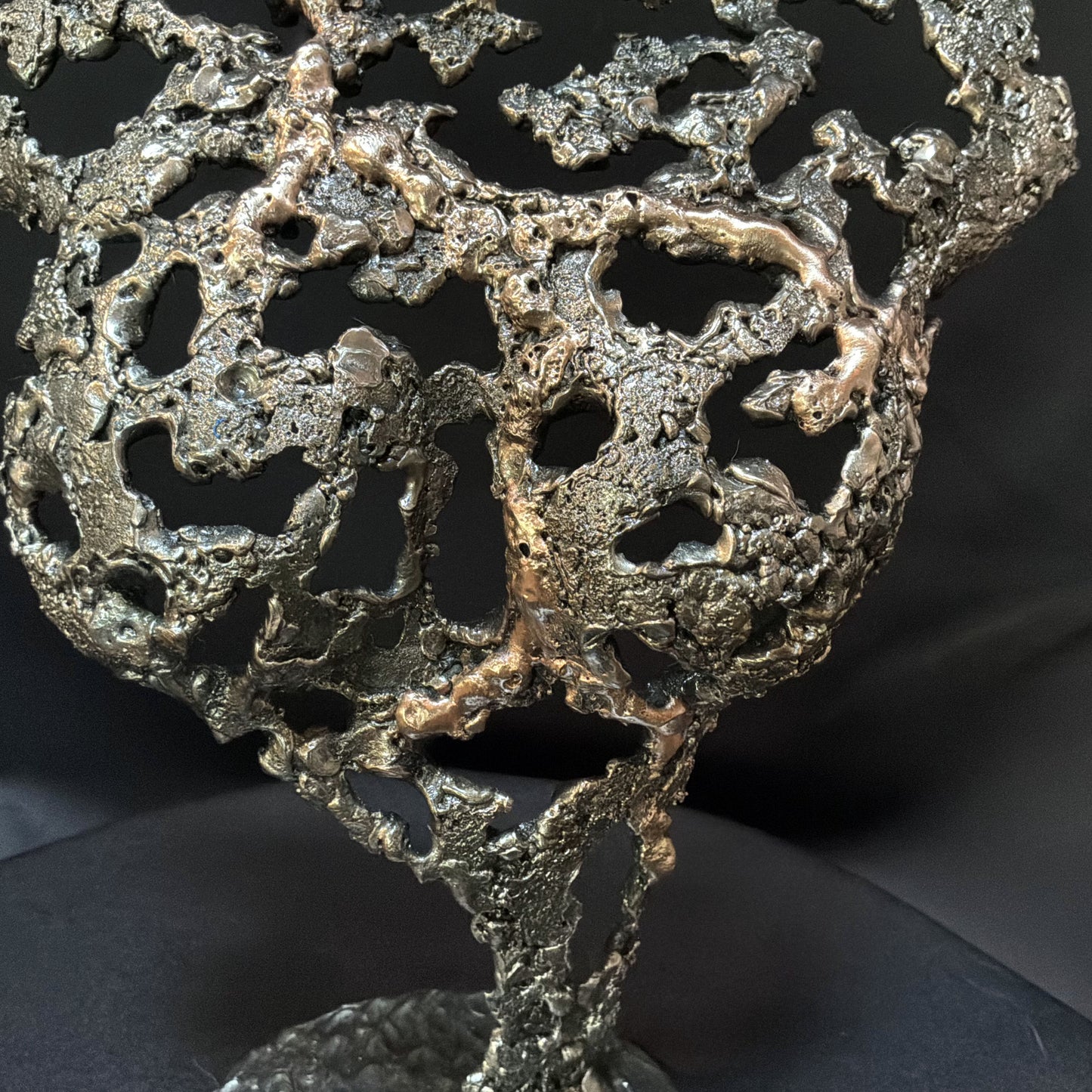 Détail de la texture organique en acier et bronze de la sculpture Pavarti Éclosion