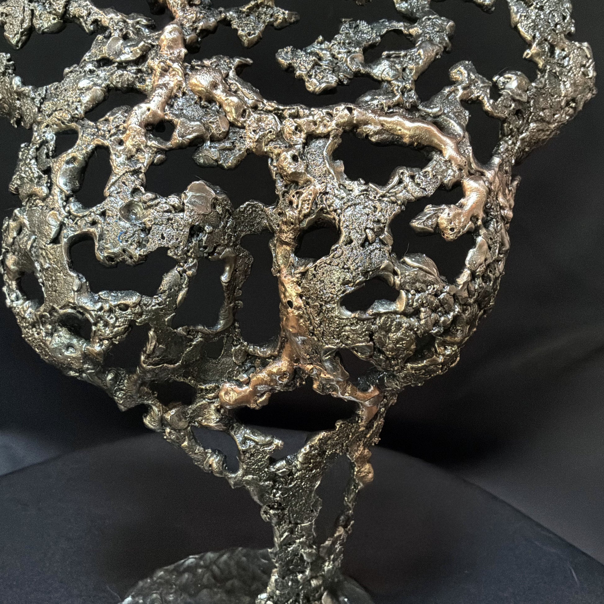 Détail de la texture organique en acier et bronze de la sculpture Pavarti Éclosion