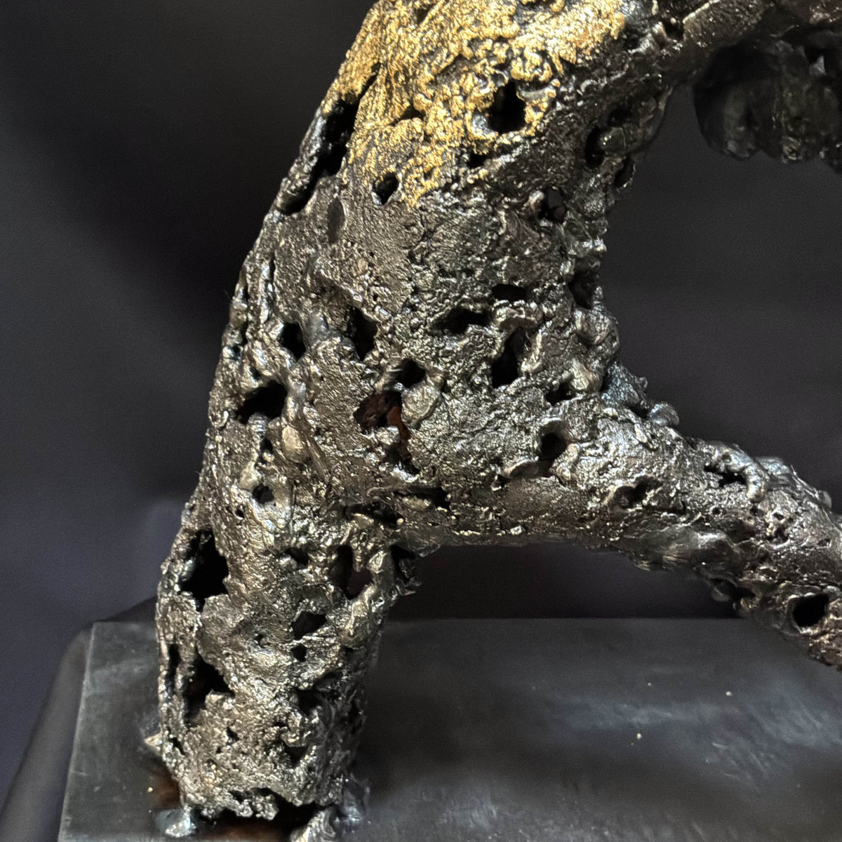Gros plan sur la texture organique de l’acier dans la sculpture contemporaine « Un échange »