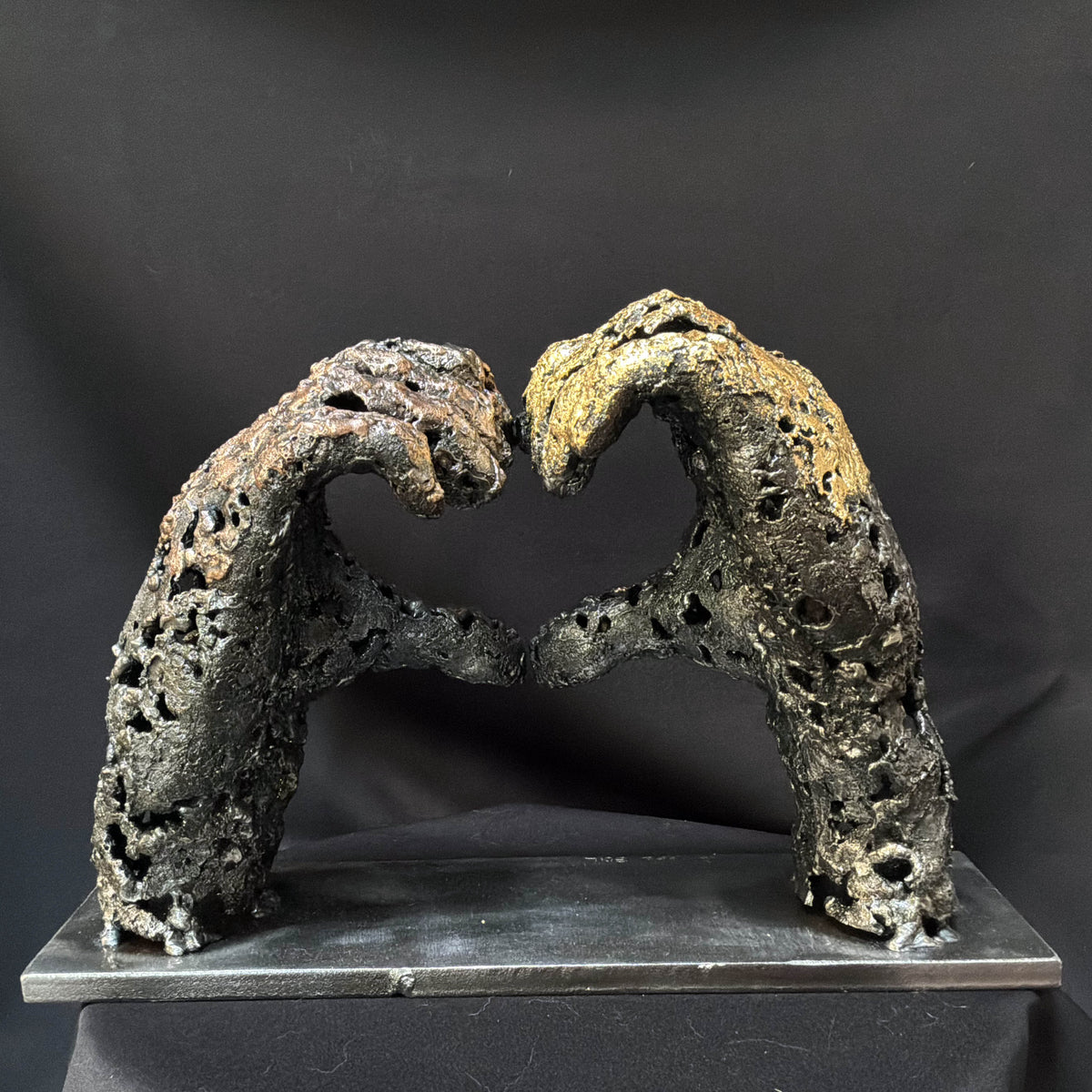 Vue arrière de la sculpture « Un échange », montrant la texture brute et ajourée de l’acier et du bronze