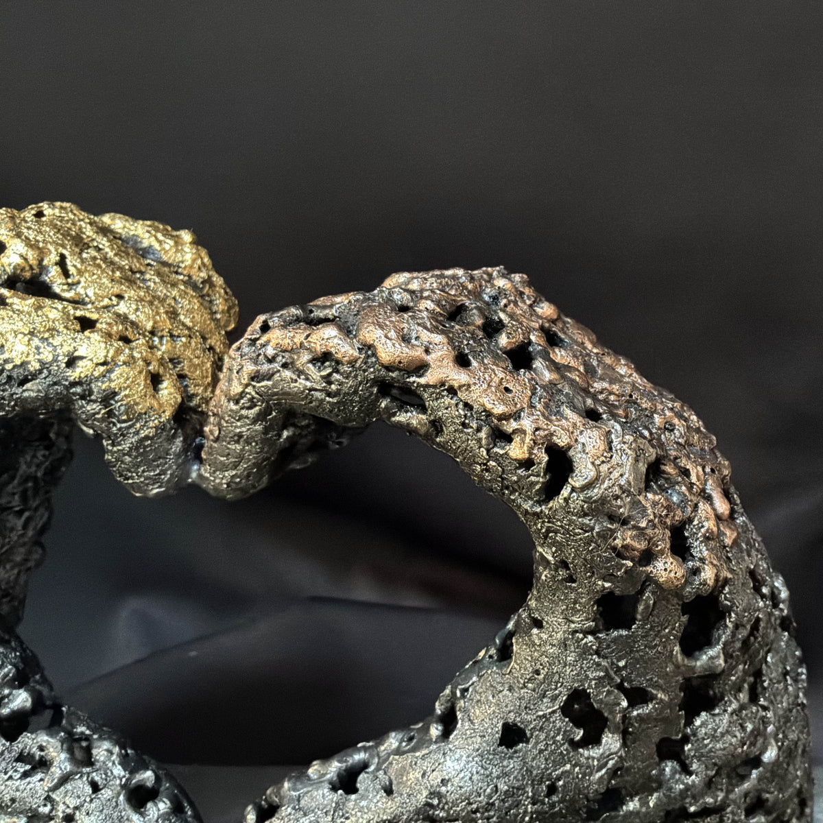 Détail des nuances métalliques du bronze et de l’acier dans la sculpture « Un échange »