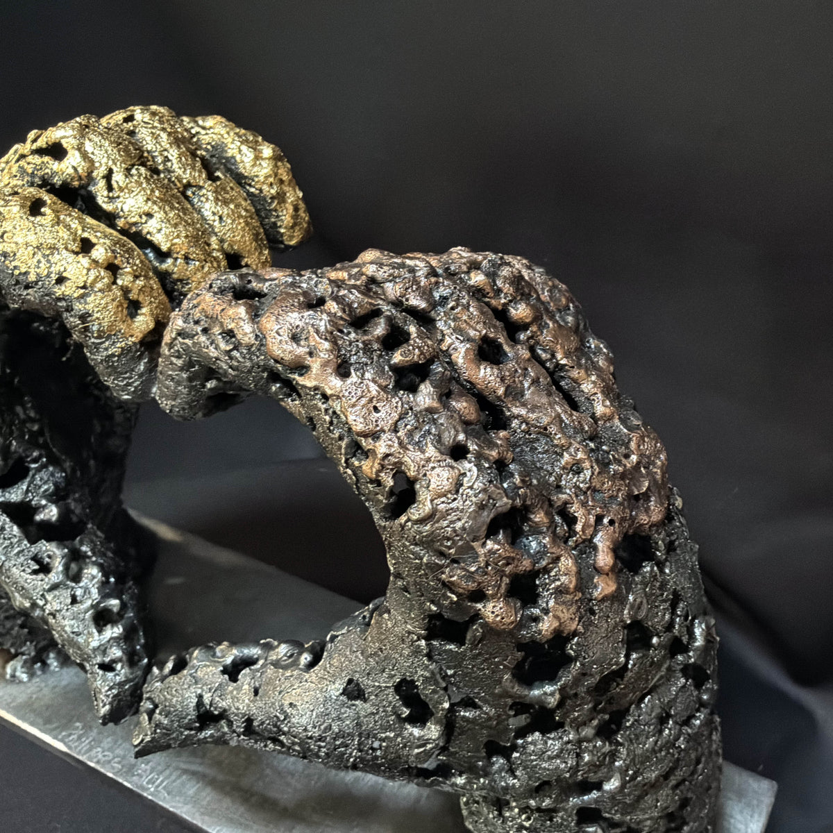 Détail de la dentelle de métal de la sculpture « Un échange », avec ses aspérités et ses ouvertures irrégulières