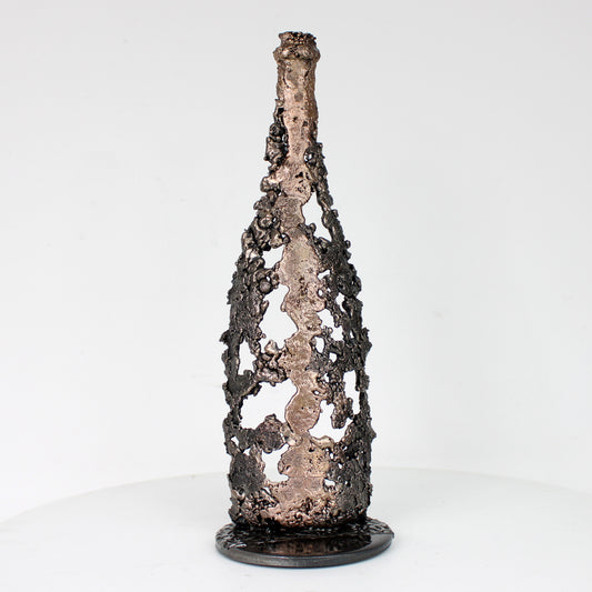 Sculpture de Philippe Buil représentant une bouteille de champagne en dentelle de métal : acier et bronze