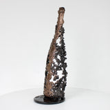 Sculpture de Philippe Buil représentant une bouteille de champagne en dentelle de métal : acier et bronze