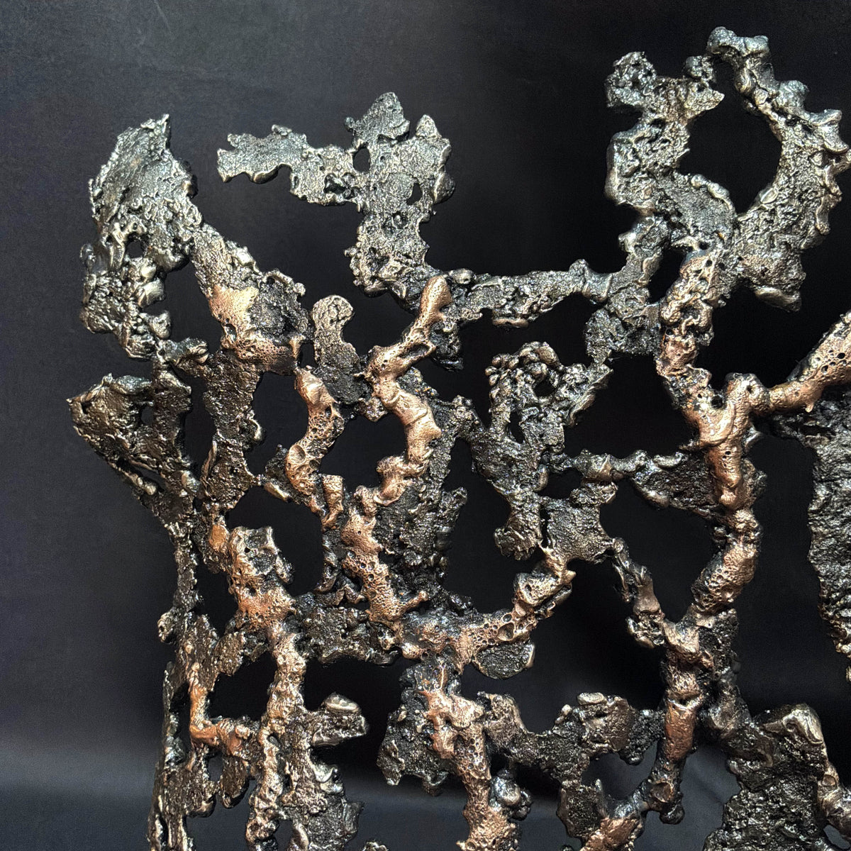 Détail de la dentelle de métal formant le buste féminin de la sculpture Au cœur du feu