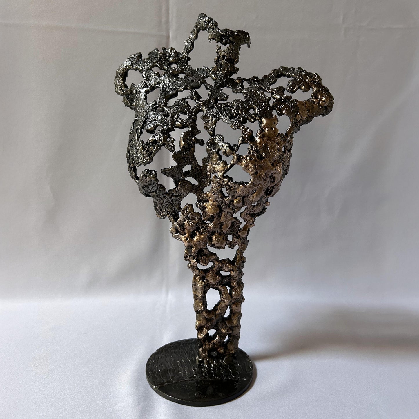 Cette sculpture de Philippe Buil représente un buste féminin, sublimé par une dentelle métallique ajourée, alliance de bronze et d'acier.