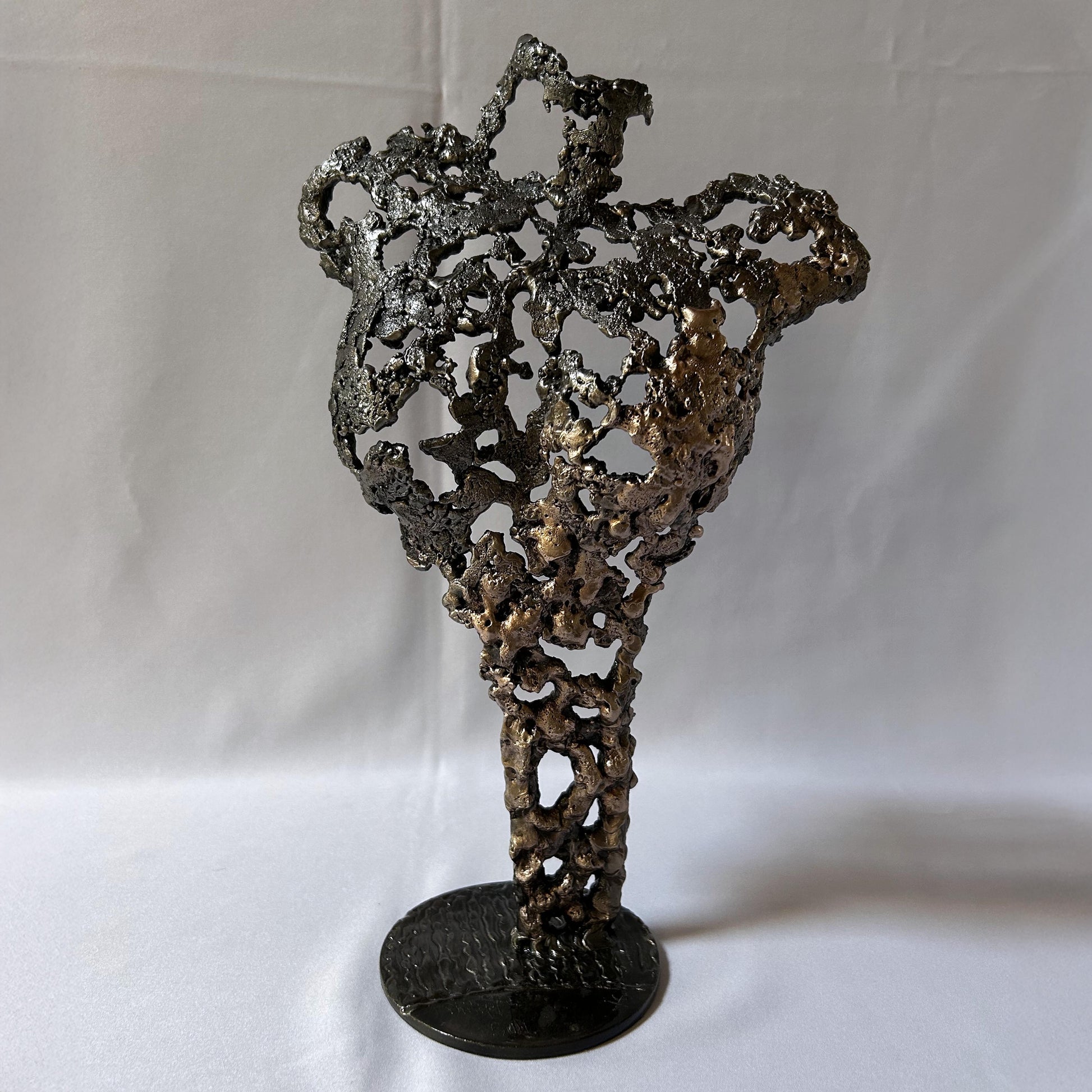 Cette sculpture de Philippe Buil représente un buste féminin, sublimé par une dentelle métallique ajourée, alliance de bronze et d'acier.