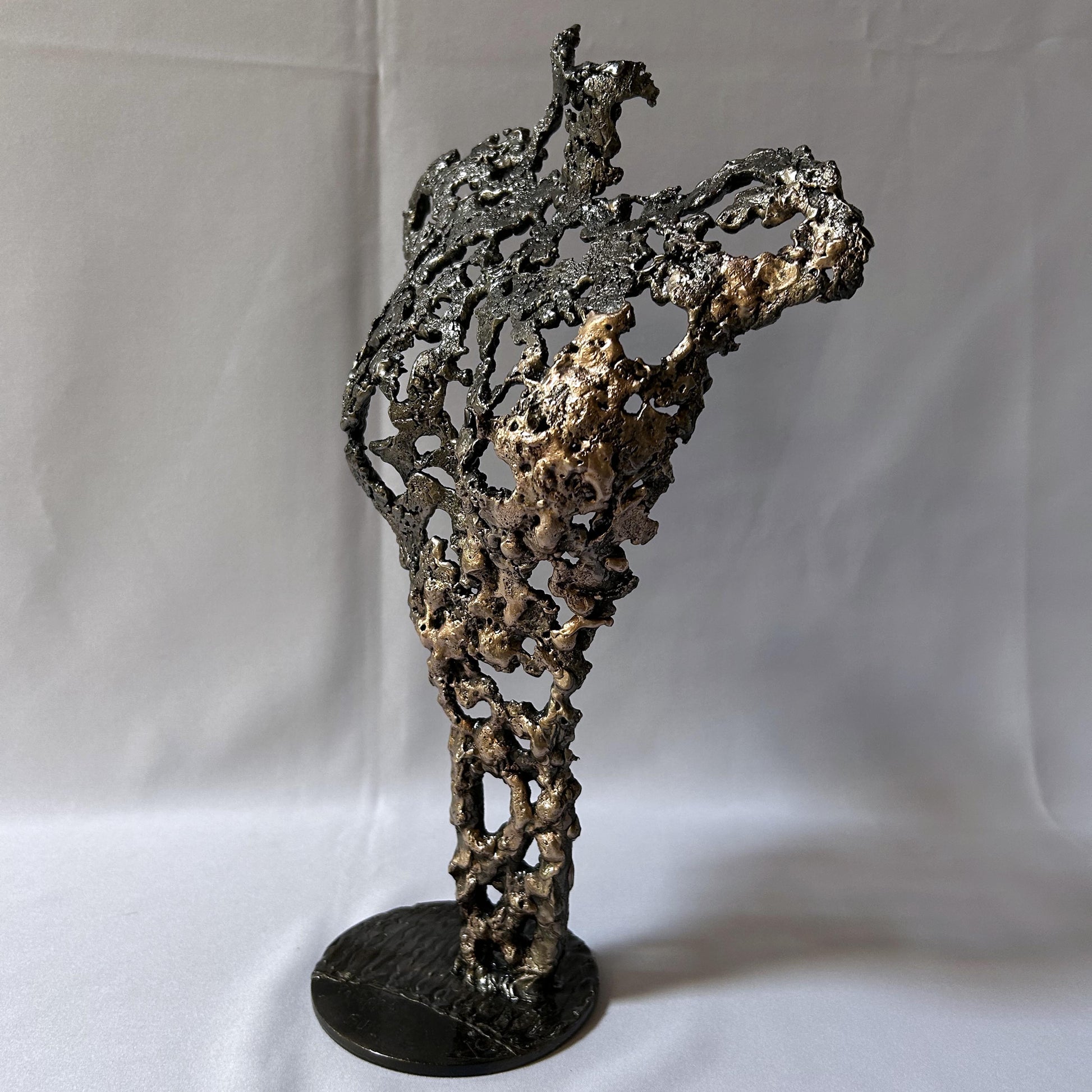 Cette sculpture de Philippe Buil représente un buste féminin, sublimé par une dentelle métallique ajourée, alliance de bronze et d'acier.