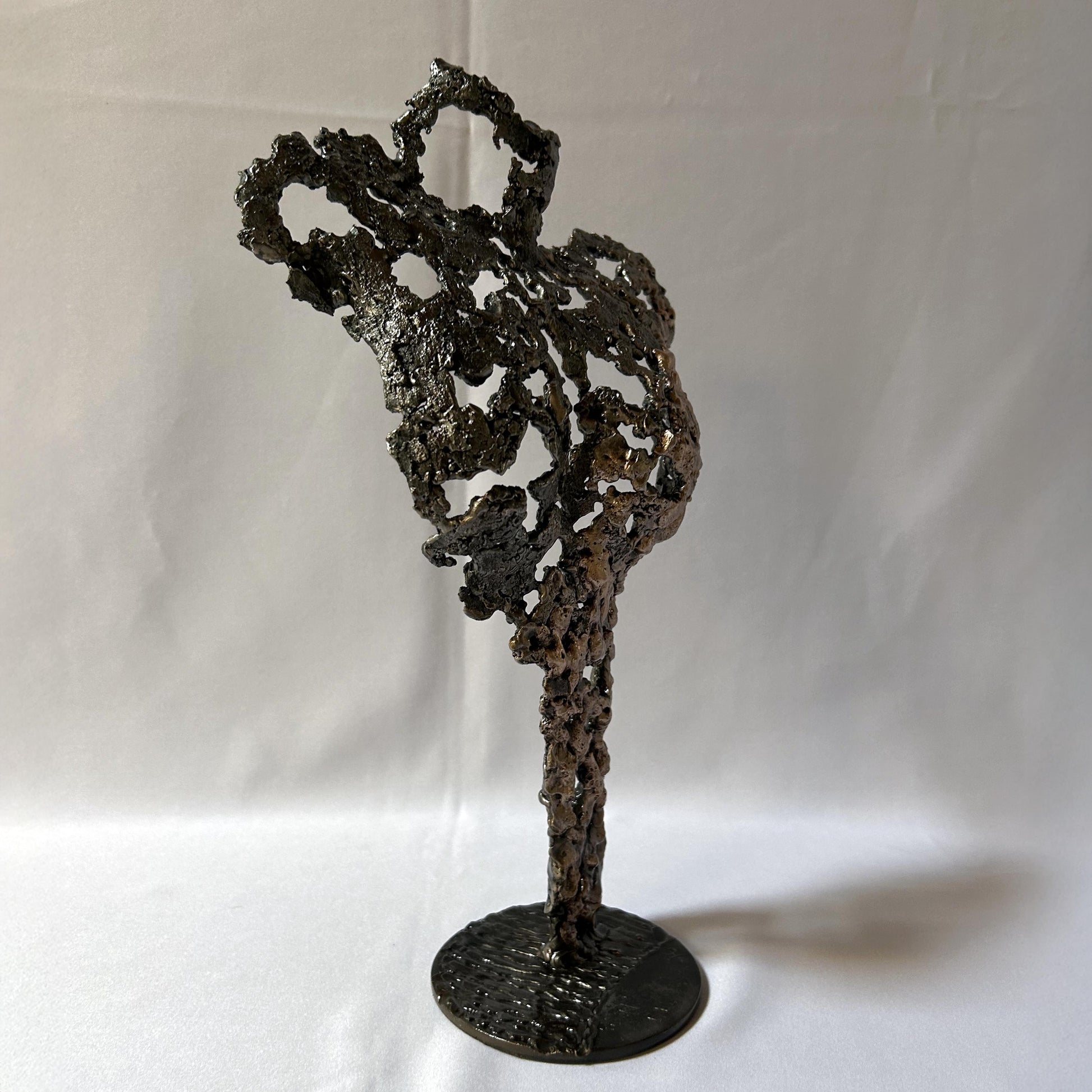 Cette sculpture de Philippe Buil représente un buste féminin, sublimé par une dentelle métallique ajourée, alliance de bronze et d'acier.