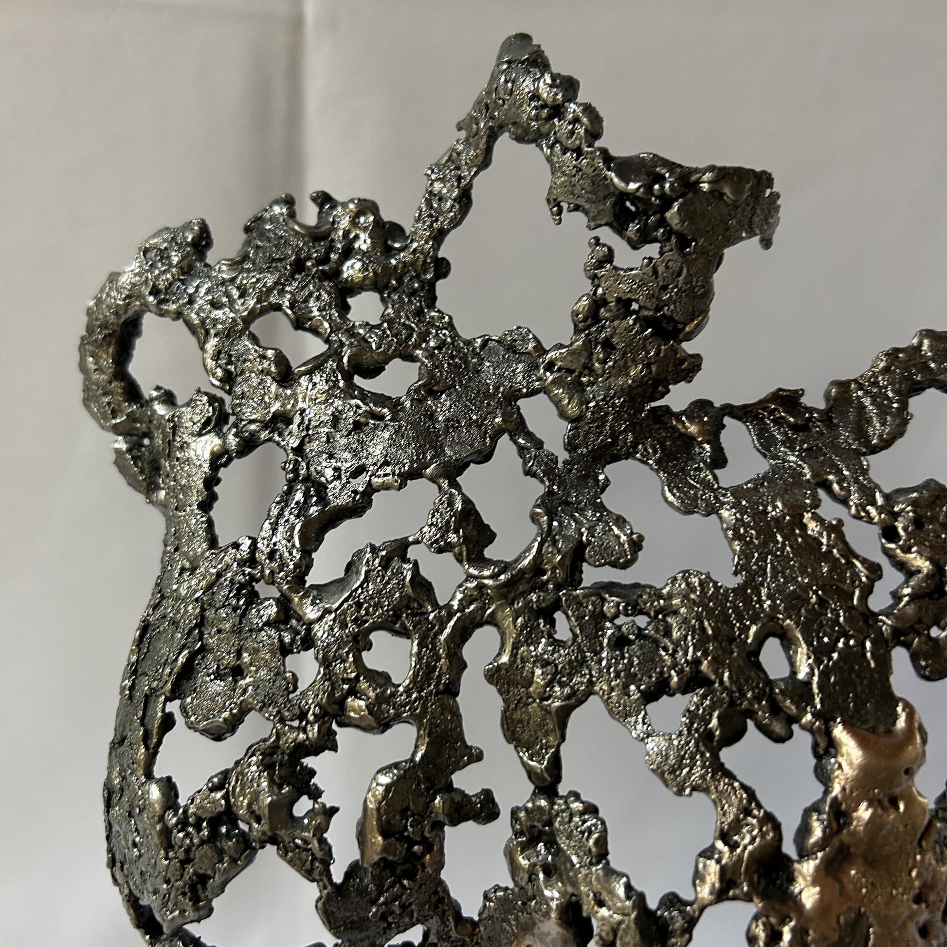 Cette sculpture de Philippe Buil représente un buste féminin, sublimé par une dentelle métallique ajourée, alliance de bronze et d'acier.