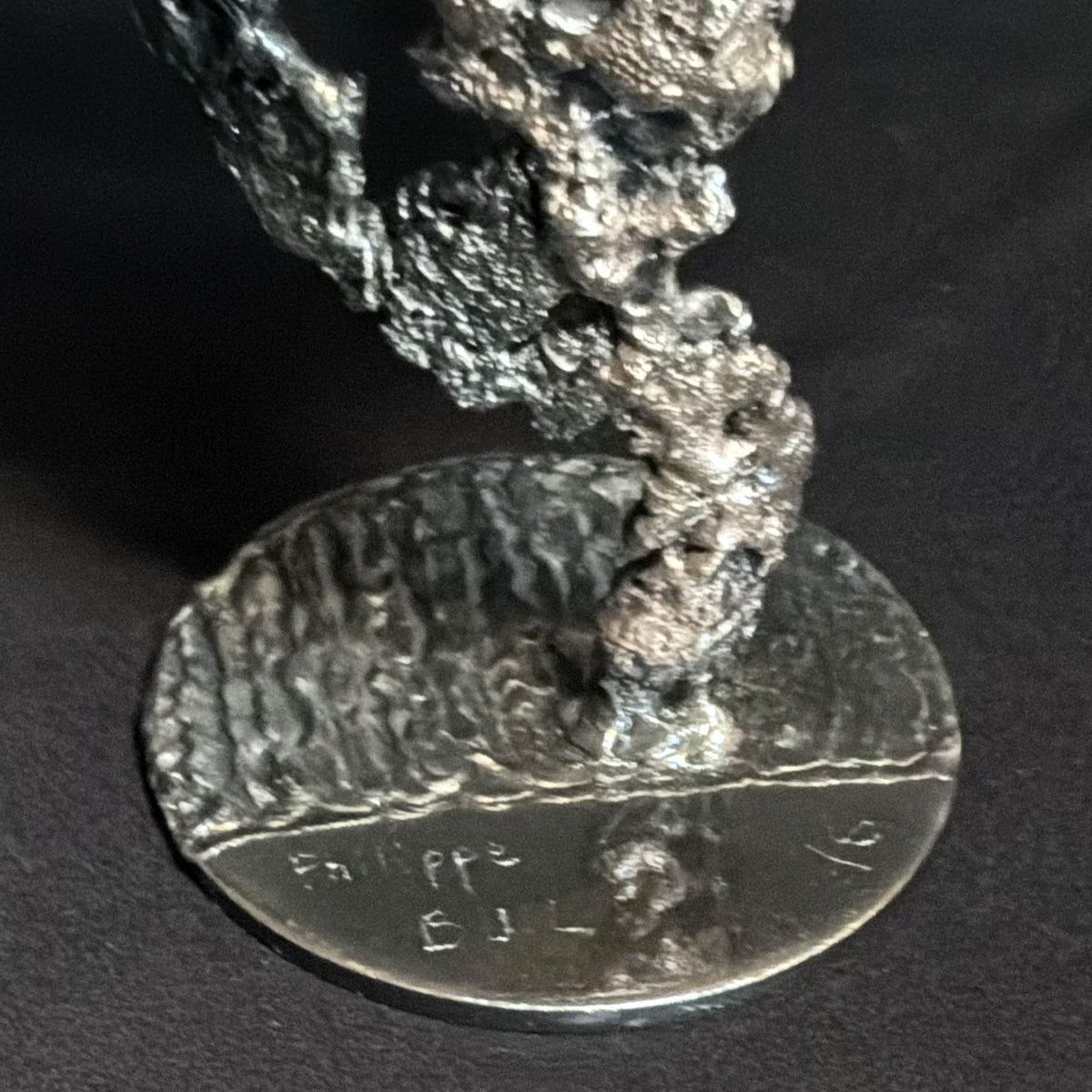 Socle de la sculpture Les Signes de Demain avec la signature de l'artiste, détail de finition de cette œuvre en dentelle de métal.