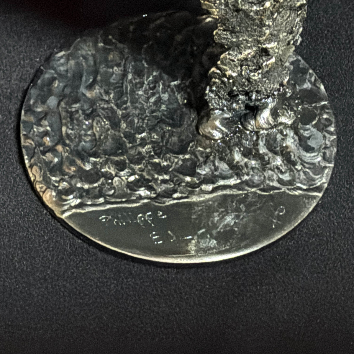 Socle de la sculpture Le Souffle du Jour avec la signature de l'artiste, détail de finition de cette œuvre en dentelle de métal.