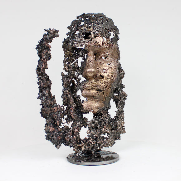 UNE LARME 52-22 - Sculpture de Philippe Buil représentant un visage émergeant d'une structure ajourée et organique, en dentelle de métal acier et bronze