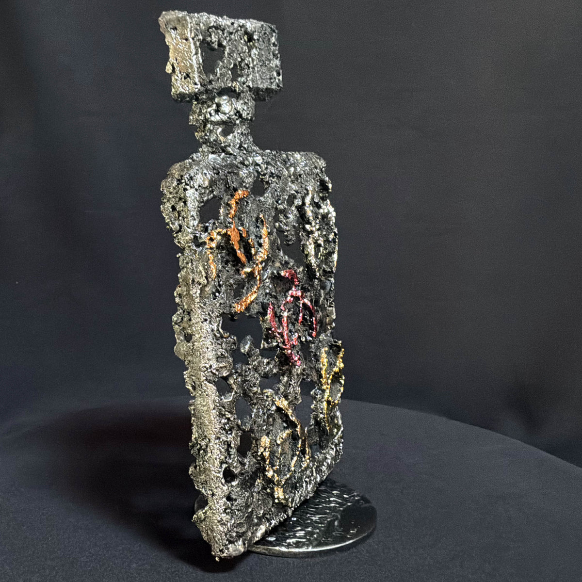 Vue de profil de la sculpture L’Essence d’une Icône révélant la structure ajourée du flacon en acier