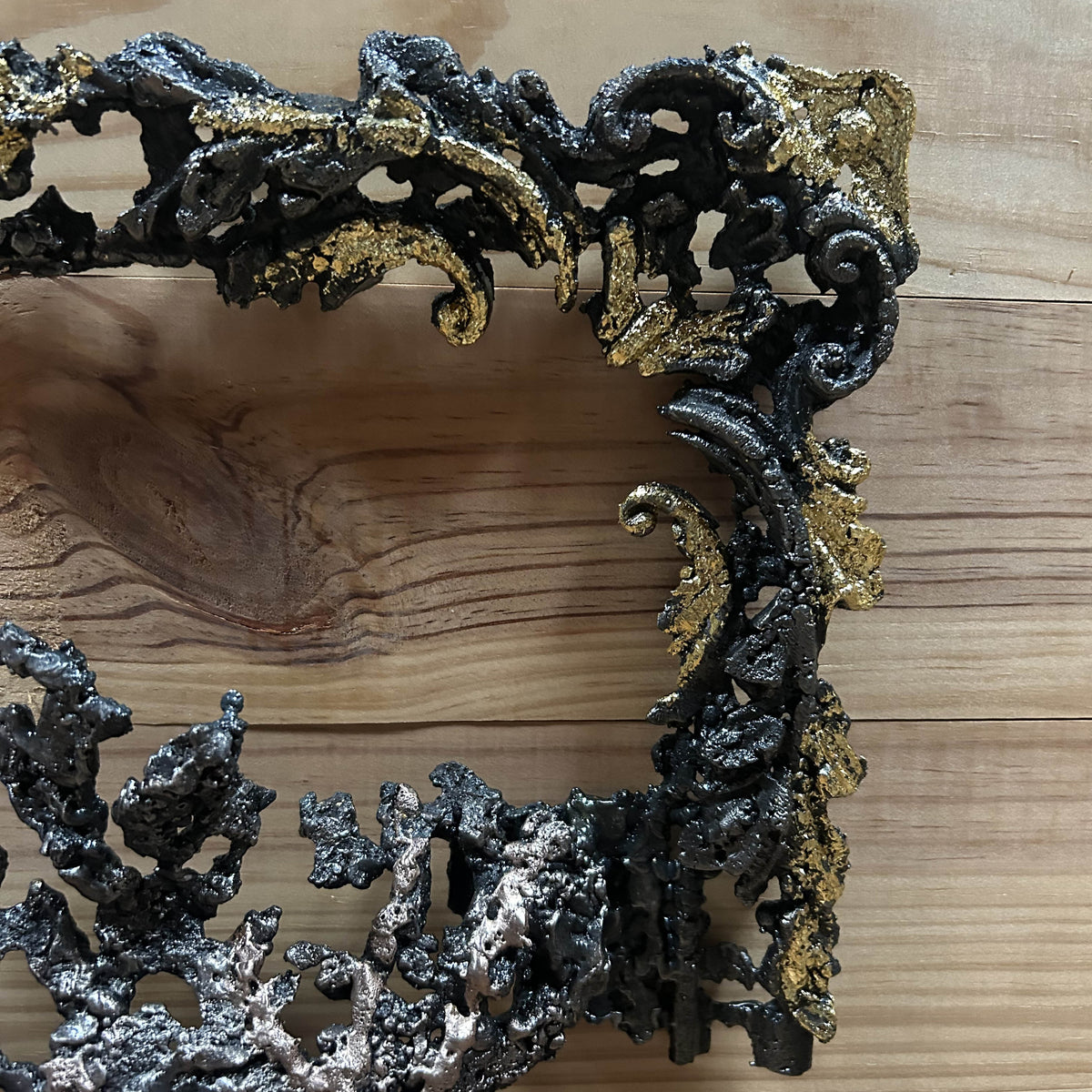Arabesques du cadre en dentelle d'acier rehaussées de feuilles métallisées dorées