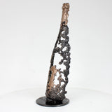 Sculpture de Philippe Buil représentant une bouteille de champagne en dentelle de métal : acier et bronze