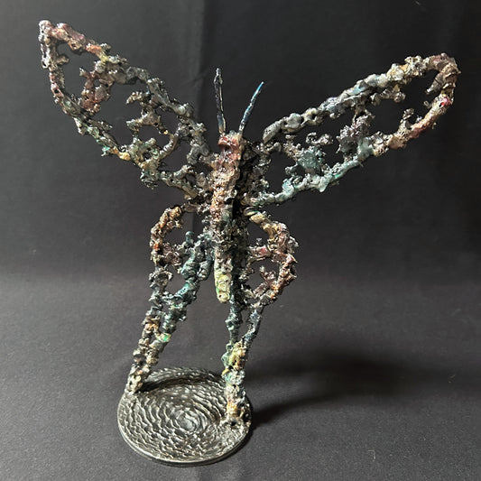 Sculpture de Philippe Buil représentant un papillon en dentelle de métal, symbole de légèreté et de transformation.