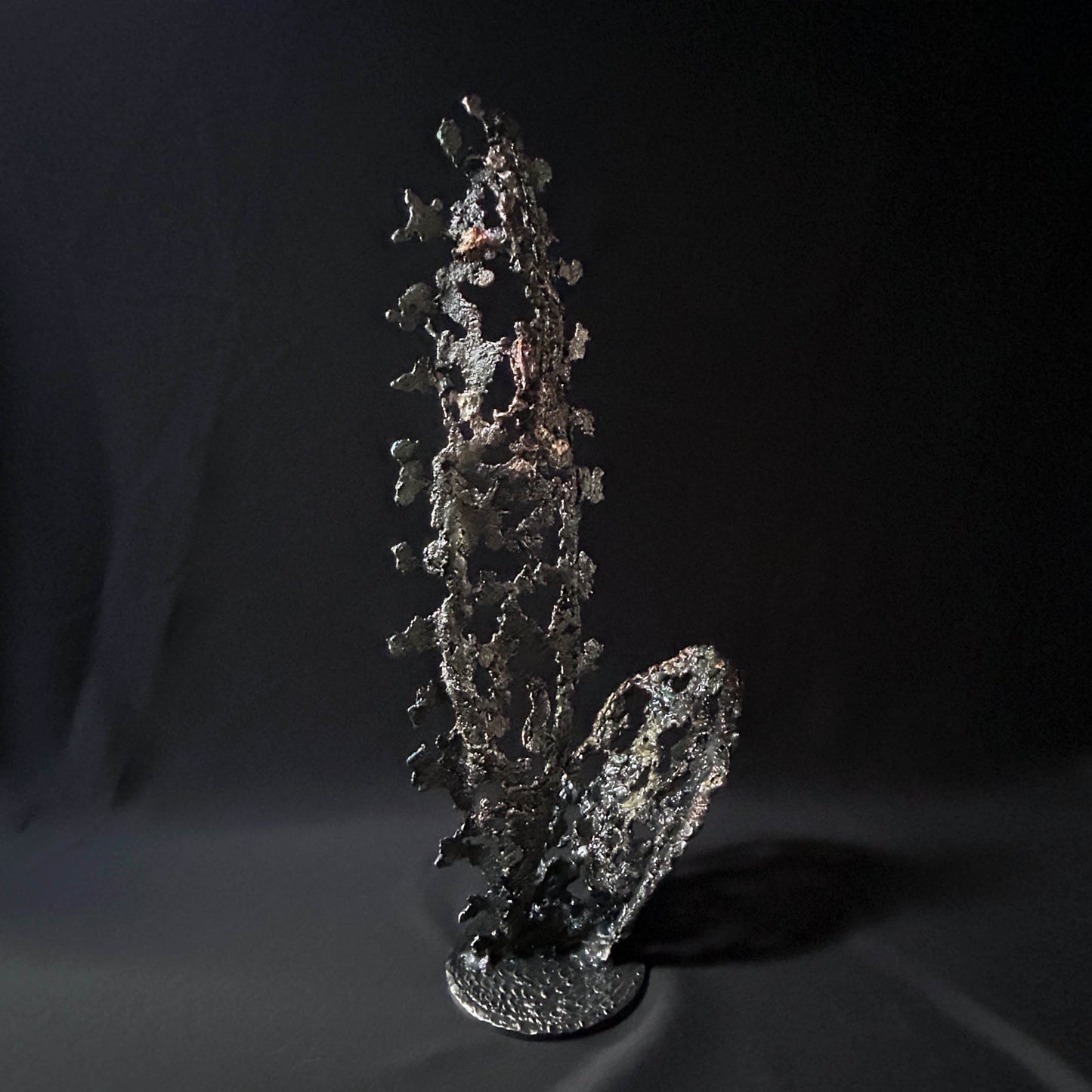Sculpture abstraite de Philippe Buil : dentelle de métal en acier et bronze, reflets irisées et formes ajourées, œuvre unique contemporaine.
