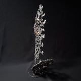 Sculpture abstraite de Philippe Buil : dentelle de métal en acier et bronze, reflets irisées et formes ajourées, œuvre unique contemporaine.