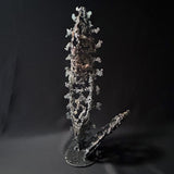 Sculpture abstraite de Philippe Buil : dentelle de métal en acier et bronze, reflets irisées et formes ajourées, œuvre unique contemporaine.