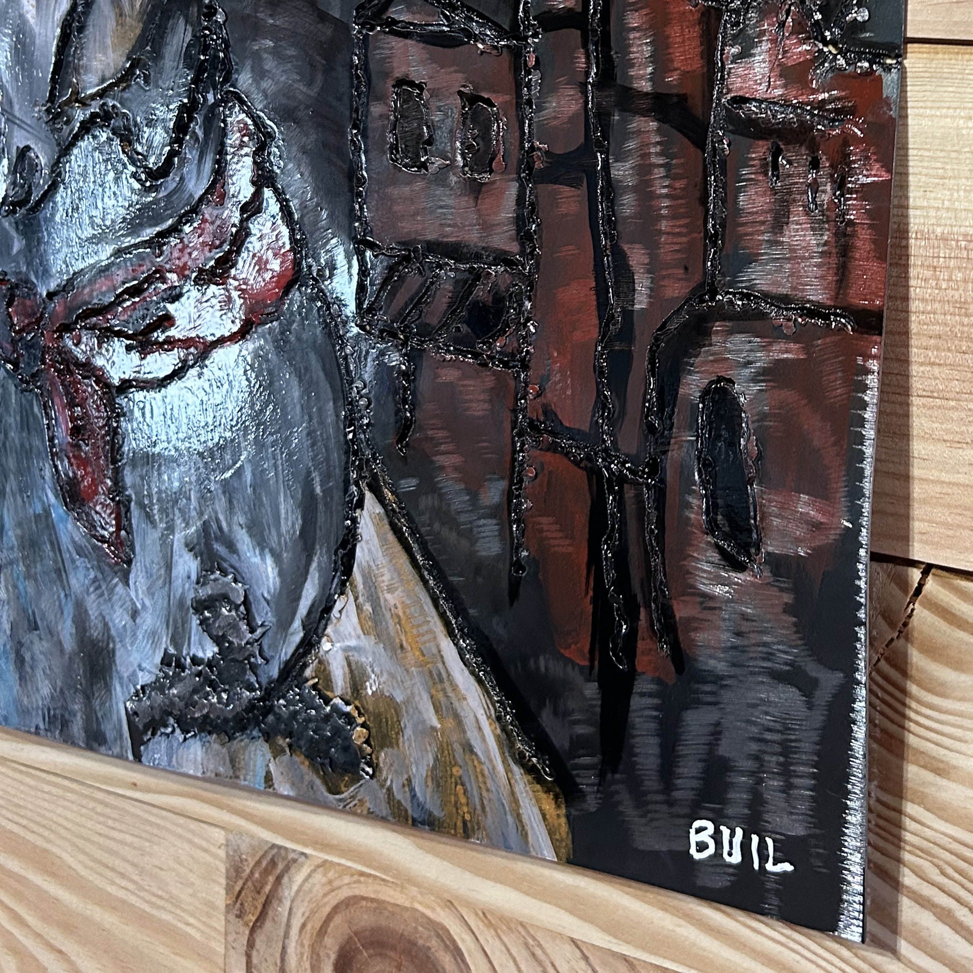 Sculpture murale en métal de Philippe Buil représentant un chien portant un béret et un foulard basque, avec pigments colorés et fond texturé sombre