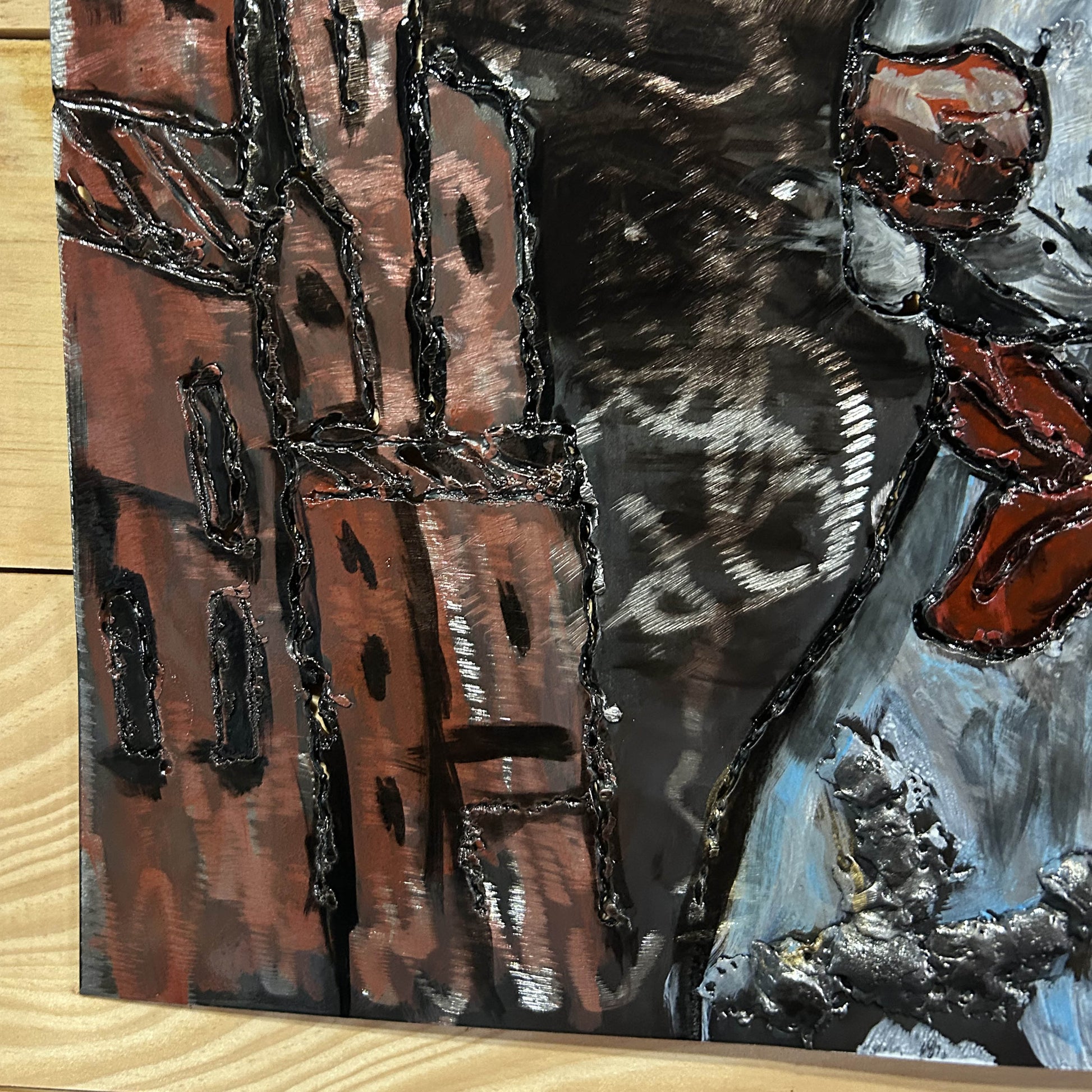 Sculpture murale en métal de Philippe Buil représentant un chien portant un béret et un foulard basque, avec pigments colorés et fond texturé sombre