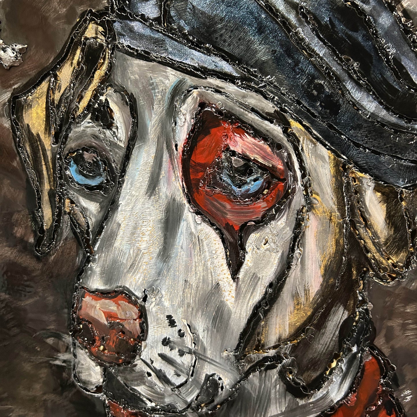 Sculpture murale en métal de Philippe Buil représentant un chien portant un béret et un foulard basque, avec pigments colorés et fond texturé sombre