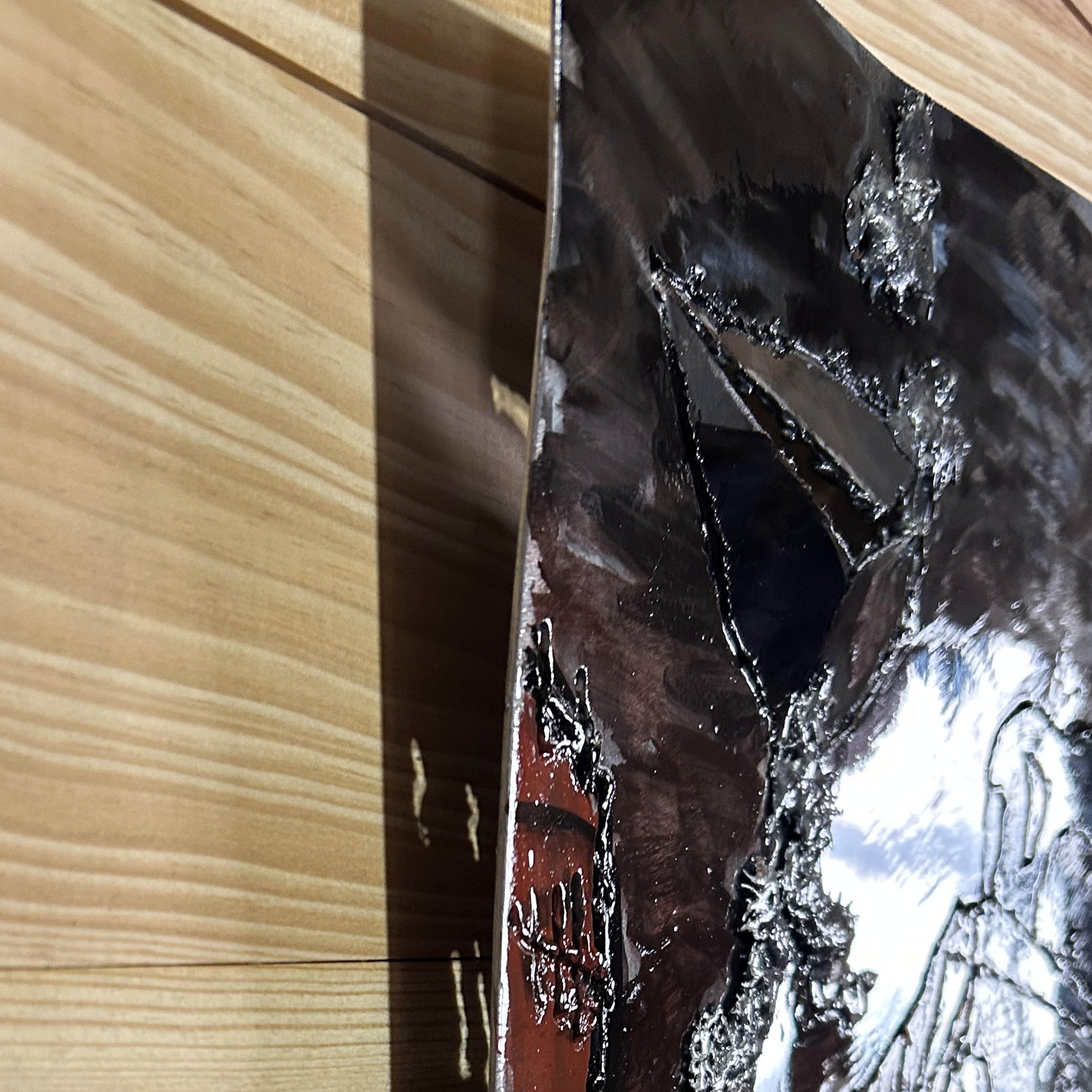 Sculpture murale en métal de Philippe Buil représentant un chien portant un béret et un foulard basque, avec pigments colorés et fond texturé sombre