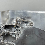 Tableau contemporain en métal de Philippe Buil représentant un visage en relief, moitié peint avec des pigments, moitié ajouré en dentelle d’acier et de bronze, créant un jeu d’ombres et de lumière.