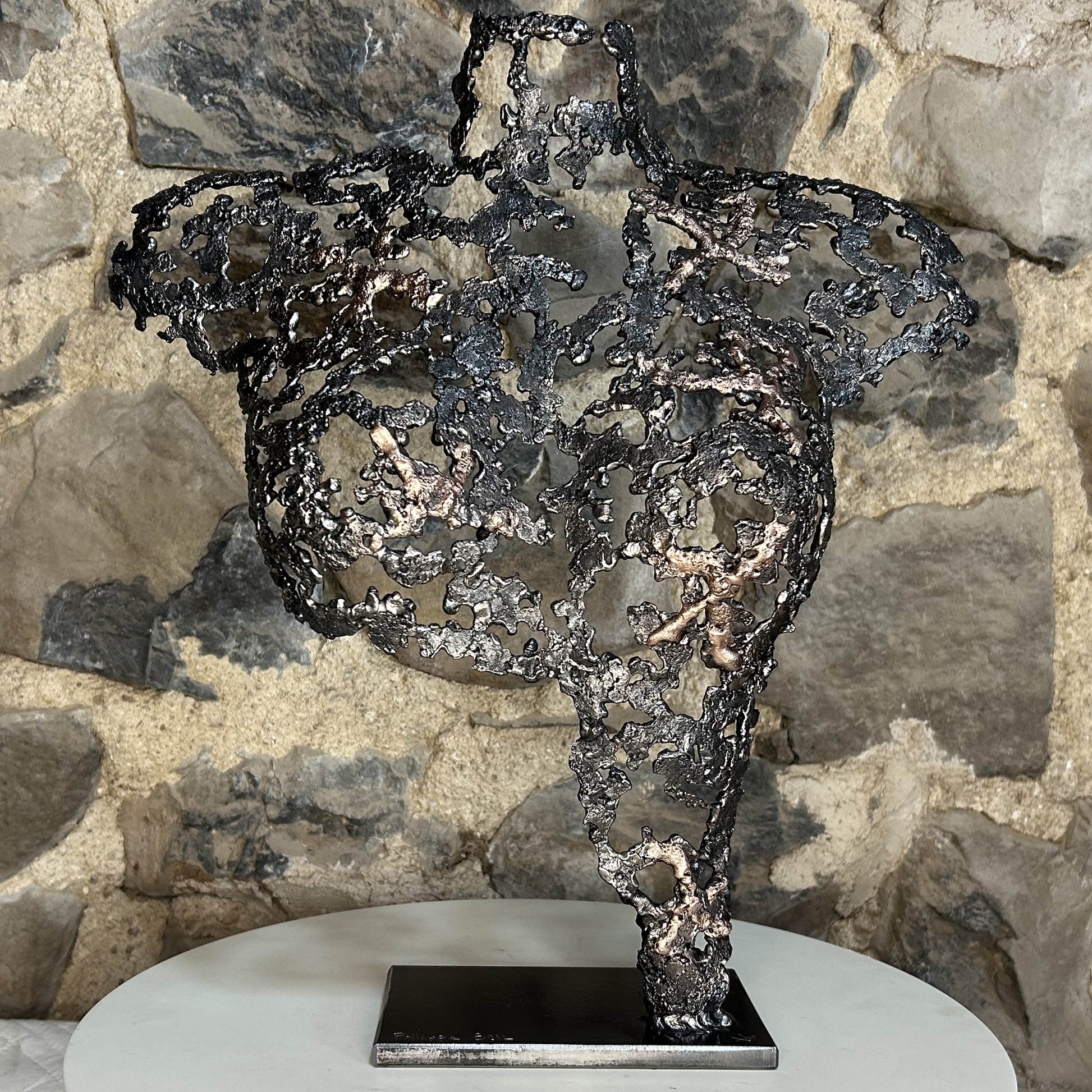 Sculpture contemporaine Belisama Le Souffle de Philippe Buil, buste de femme à taille réelle en dentelle de métal acier et bronze avec étoiles fondues, vue de face sur fond sombre.