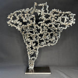 Sculpture contemporaine Belisama Le Souffle de Philippe Buil, buste de femme à taille réelle en dentelle de métal acier et bronze avec étoiles fondues, vue de dos sur fond sombre.