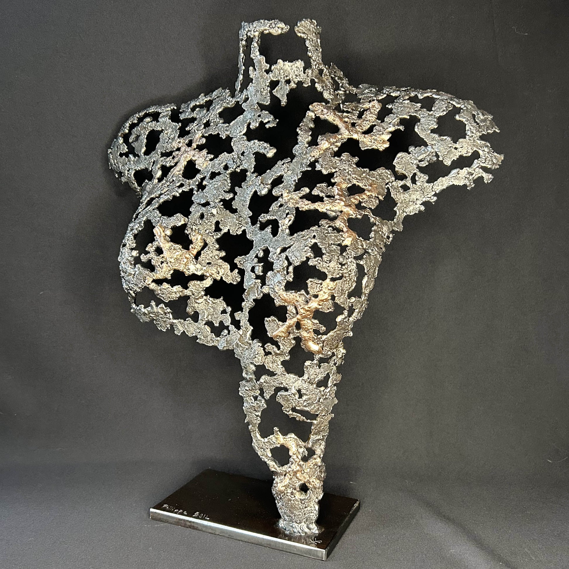 Sculpture contemporaine Belisama Le Souffle de Philippe Buil, buste de femme à taille réelle en dentelle de métal acier et bronze avec étoiles fondues, vue de profil sur fond sombre.