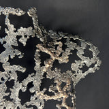 Détail Sculpture contemporaine Belisama Le Souffle de Philippe Buil, buste de femme à taille réelle en dentelle de métal acier et bronze avec étoiles fondues,  sur fond sombre.