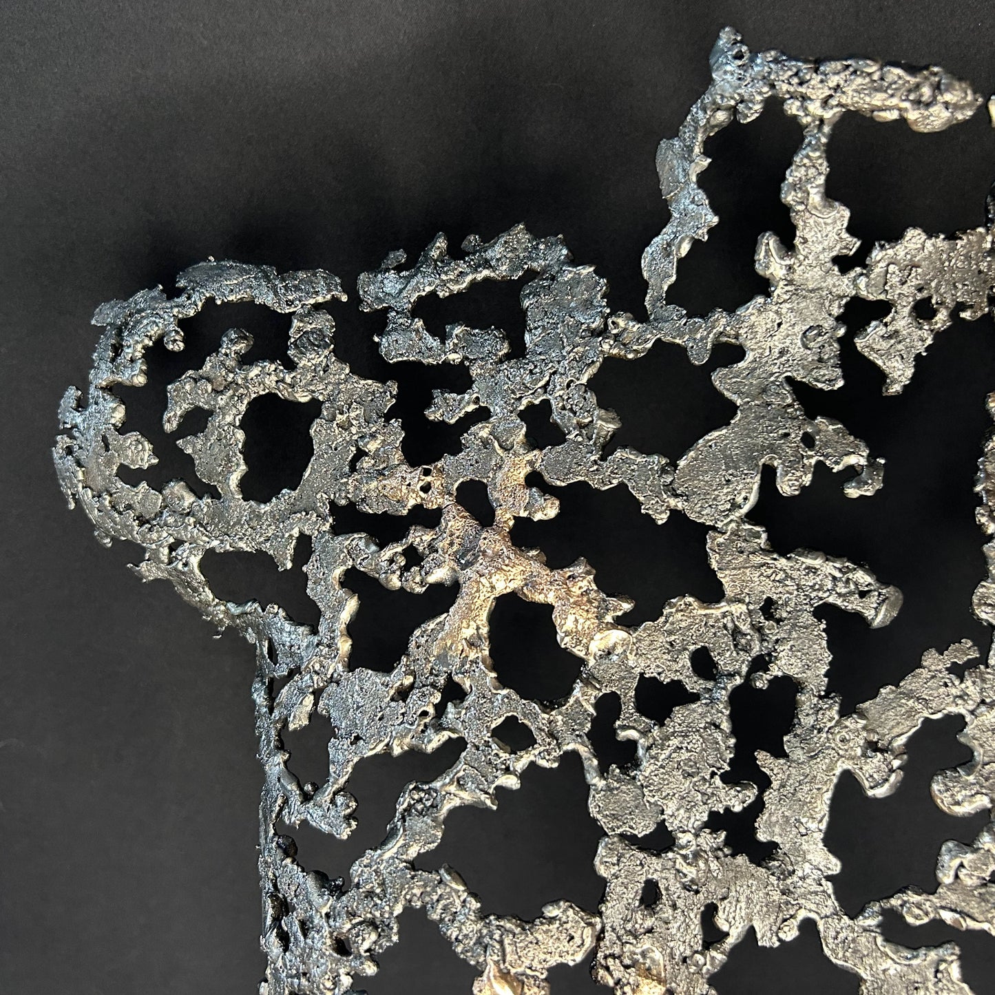 Détail Sculpture contemporaine Belisama Le Souffle de Philippe Buil, buste de femme à taille réelle en dentelle de métal acier et bronze avec étoiles fondues,  sur fond sombre.